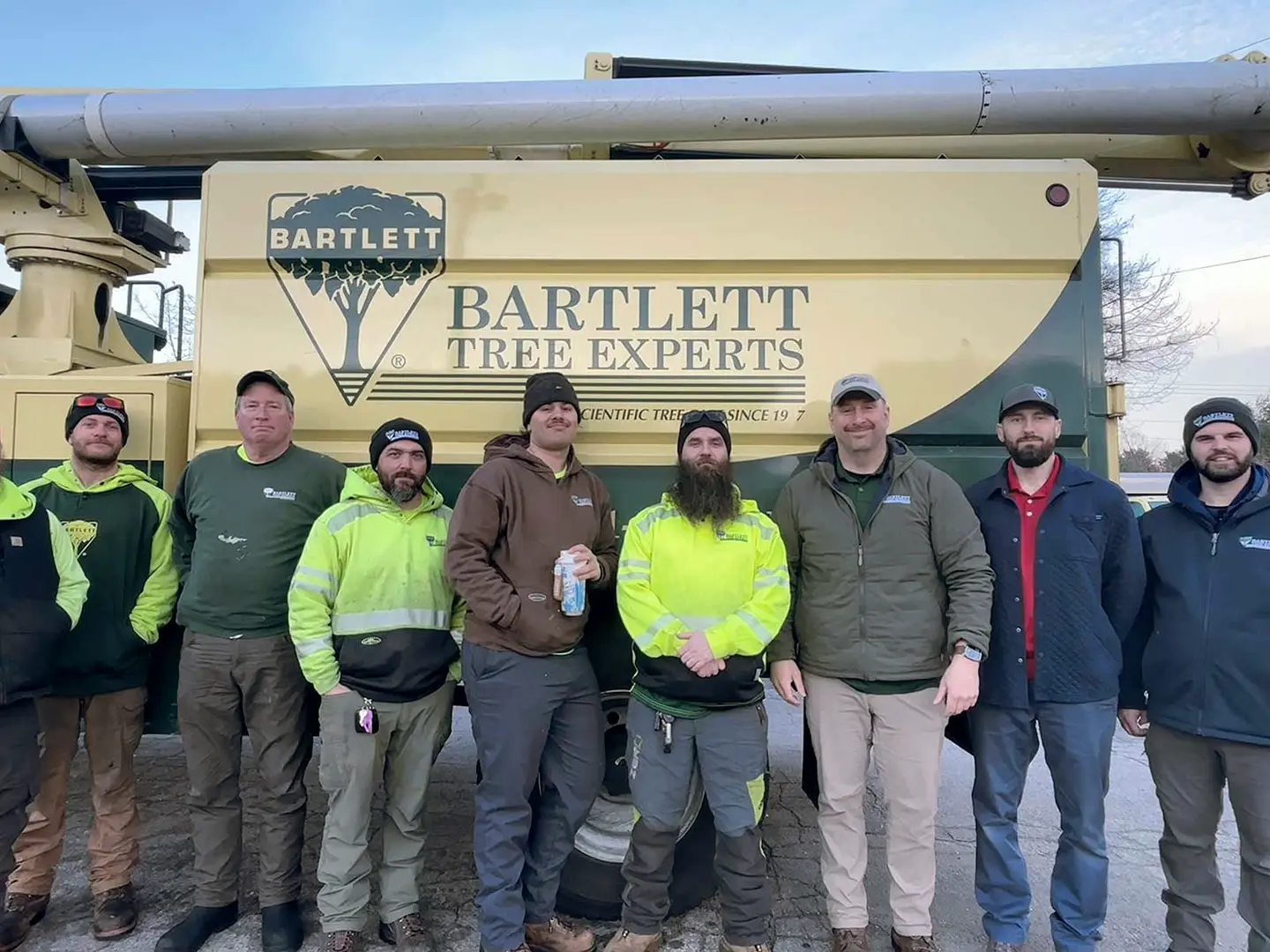 Bartlett crew standing in front of a branded Bartlett aerial lift truck